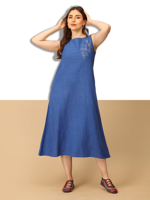 Woman wearing a blue dress with floral embroidery on a beige background